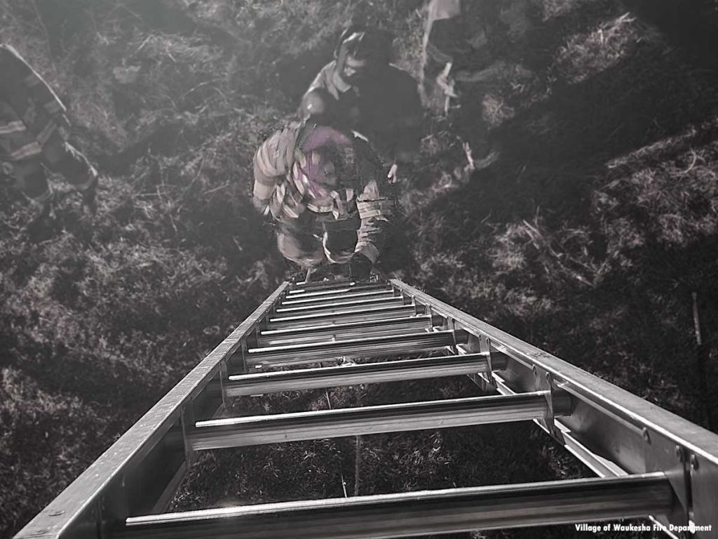 Waukesha firefighter climbing a ladder