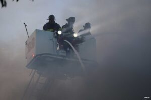 Three firefighters in a tower ladder bucket