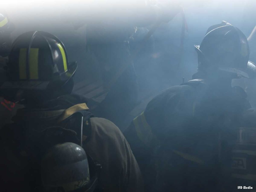 Two firefighters with helmets on